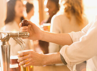 Nahaufnahme Barkeeper gießt Bier am Zapfhahn in einer Bar aus - HOXF01480