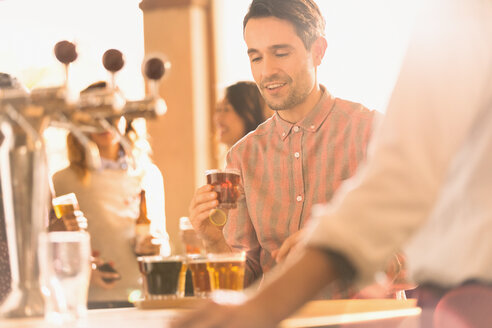 Mann probiert Bier in der Bar einer Kleinbrauerei - HOXF01501