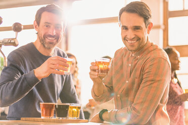 Portrait smiling men friends sampling beer at microbrewery bar - HOXF01516