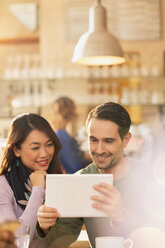 Couple using digital tablet in cafe - HOXF01518