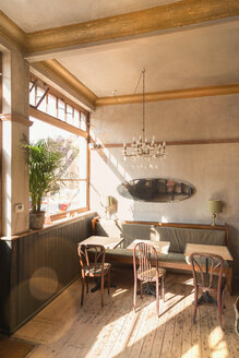 Holztisch mit Stühlen und Stand in leeren Vintage-Café - HOXF01532