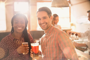 Portrait lächelndes Paar beim Biertrinken in einer Bar - HOXF01546