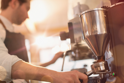 Barista mit Espressomaschine und Mühle im Café, lizenzfreies Stockfoto