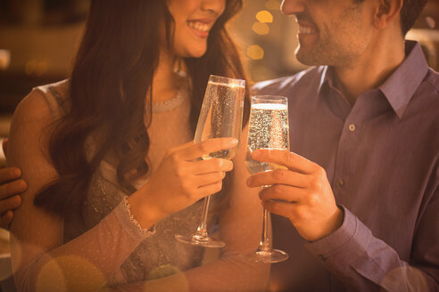 Verliebtes Paar stößt mit Champagnerflöten an - HOXF01552