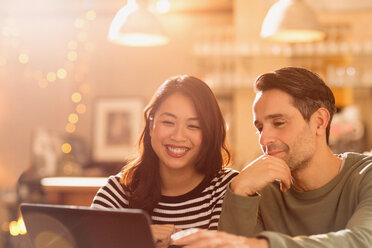 Lächelndes Paar beim Videochat am Laptop im Café - HOXF01555