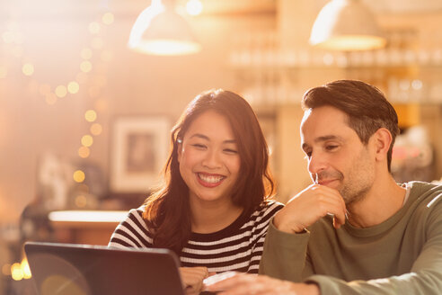 Lächelndes Paar beim Videochat am Laptop im Café - HOXF01555