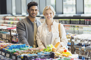 Portrait lächelndes junges Paar beim Einkaufen auf dem Markt - HOXF01575