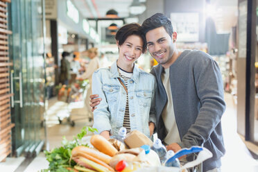 Portrait lächelndes junges Paar beim Einkaufen auf dem Markt - HOXF01610