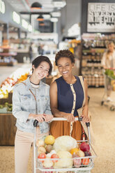 Porträt lächelnd junge lesbische Paar mit Einkaufswagen Lebensmittelgeschäft Einkaufen in Markt - HOXF01628