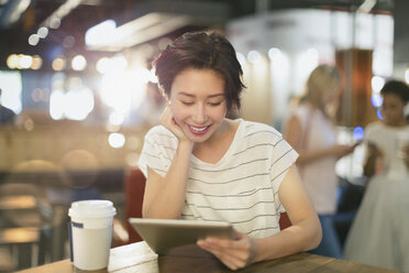 Young woman using digital tablet and drinking coffee in cafe - HOXF01648