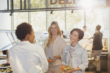 Young women friends at salad bar in grocery store market - HOXF01655