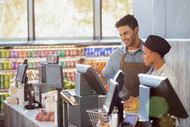 Cashiers working at grocery store checkout - HOXF01682