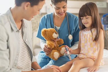Weibliche Krankenschwester mit Teddybär beobachtet Mädchen Patient mit Insulin-Pen im Krankenhaus Zimmer - HOXF01746