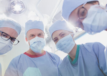 Portrait confident surgeons wearing surgical masks in operating room - HOXF01769