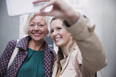 Lächelnde Mutter und Tochter nehmen Selfie mit Kamera-Handy - HOXF01837