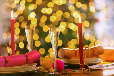 Champagnerflöten, Kerzen und Weihnachtsgebäck auf dem Esstisch - HOXF01862