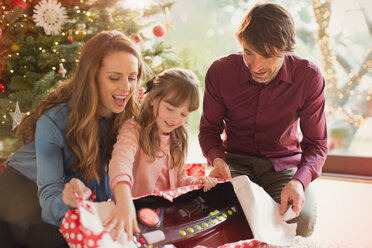 Eltern beobachten, wie ihre Tochter ein Weihnachtsgeschenk öffnet - HOXF01877