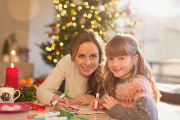 Porträt lächelnd Mutter und Tochter Färbung mit Markern in Weihnachten Wohnzimmer - HOXF01898