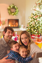 Dumme Familie macht Selfie mit Fotohandy im Weihnachtswohnzimmer - HOXF01899