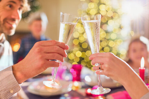 Ehepaar stößt beim Weihnachtsessen mit Champagnerflöten an - HOXF01903