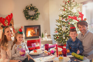 Porträt lächelnd junge Familie tragen Kostüm Rentiergeweih an Weihnachten Abendessen Tabelle - HOXF01923