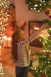 Girl hanging ornament on Christmas tree - HOXF01943