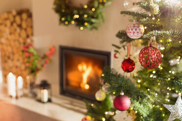 Roter und weißer Weihnachtsschmuck am Weihnachtsbaum neben dem Kamin - HOXF01955