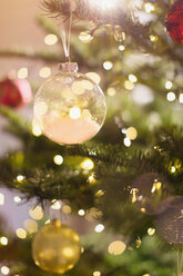 Close up snow ornament hanging from Christmas tree - HOXF01958