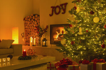 Stimmungsvoller Kamin und Kerzen im Wohnzimmer mit Weihnachtsbaum - HOXF01970