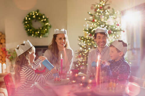 Familie mit Papierkronen am Weihnachtstisch - HOXF01977