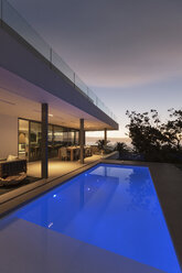 Tranquil blue lap swimming pool outside modern luxury home showcase exterior - HOXF01984