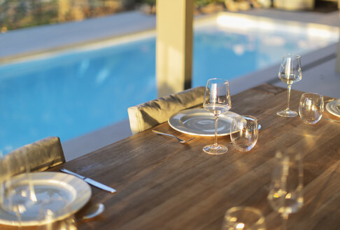 Platzierungen auf dem Terrassentisch aus Holz am Pool - HOXF01996