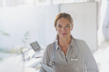 Portrait confident female doctor with digital tablet in doctor’s office - HOXF02023