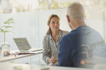 Female doctor talking with male patient in doctor’s office - HOXF02032