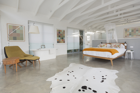 Modernes, minimalistisches Haus mit Hotelzimmer mit Holzbalkengewölbe und Badewanne, lizenzfreies Stockfoto