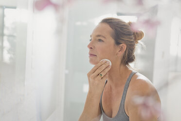 Ältere Frau trägt Make-up im Badezimmerspiegel auf - HOXF02064