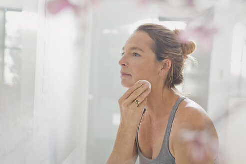 Mature woman applying makeup in bathroom mirror - HOXF02064