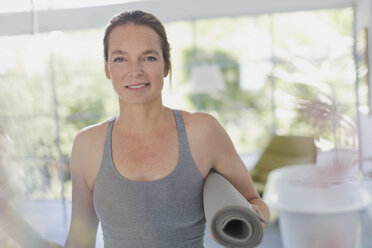 Porträt lächelnde reife Frau hält Yogamatte - HOXF02088