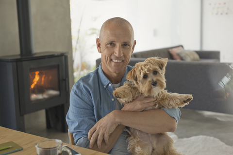 Porträt lächelnd reifen Mann hält niedlichen Hund, lizenzfreies Stockfoto