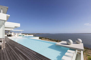 Sonniges, ruhiges, modernes Luxushaus mit Infinity-Pool im Freien und Meerblick unter blauem Himmel - HOXF02097