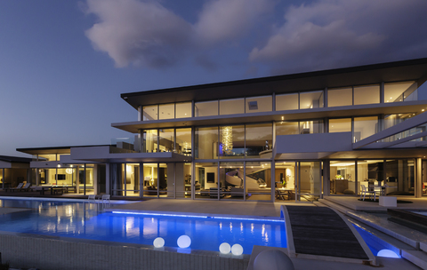 Beleuchtete moderne Luxuswohnung mit Swimmingpool bei Nacht, lizenzfreies Stockfoto
