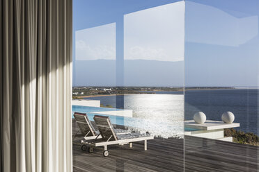 Blick aus dem Fenster auf die sonnige, moderne und luxuriöse Terrasse mit Infinity-Pool und Meerblick - HOXF02137