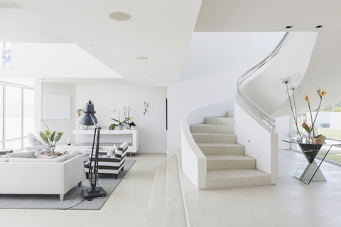 White modern luxury home showcase spiral staircase and living room stock photo