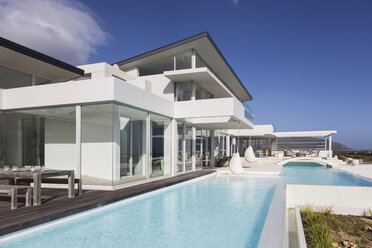 Sunny, tranquil modern luxury home showcase exterior with swimming pool - HOXF02149