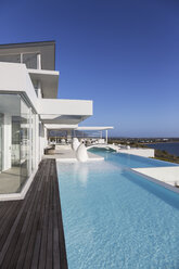Sunny, tranquil modern luxury home showcase exterior with infinity pool - HOXF02152