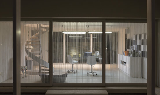 Beleuchtetes modernes Haus Schaufenster Innenraum Büro bei Nacht - HOXF02160