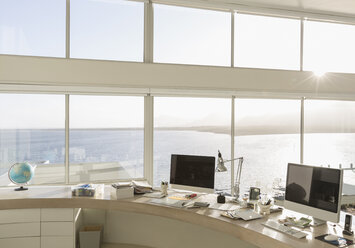 Sunny, tranquil modern luxury home showcase interior home office with ocean view - HOXF02164