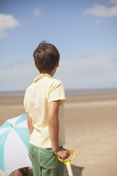 Pensive boy looking away on sunny summer beach - HOXF02177