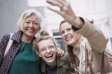 Lachende Mutter und Töchter machen ein Selfie - HOXF02197