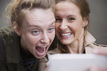 Verspielte, lachende Freundinnen, die ein Selfie mit einem Fotohandy machen - HOXF02202